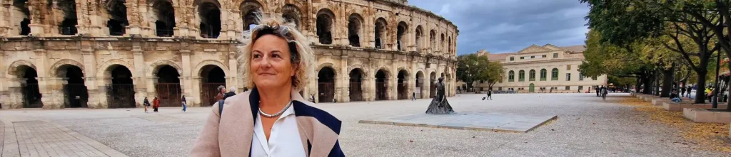 Tourisme dans le Gard. Belle femme devant les arènes de Nîmes