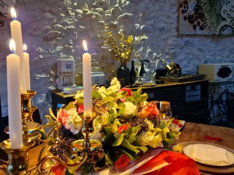 La Table d'Hôtes avec un énorme bouquet et une grande bougie