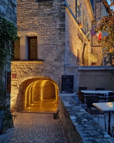 Passage couvert dans une ruelle pavée à la tombée de la nuit